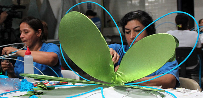 Manos embadurnadas de pegante dan vida a las figuras del alumbrado caleo